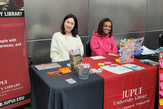 Students sitting at IUPUI Library information table.